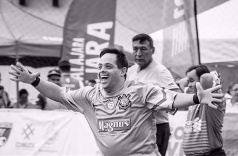 Imagem de Danilo, portador de síndrome de Down e goleiro da equipe de futsal do Corinthians, que comemora vitória com os braços abertos